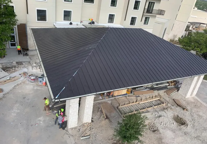 Metal roofing installation team working on a commercial building in Erie