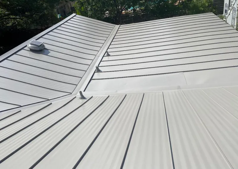Solar attic fan installed on a metal roof for Roof Ventilation in Erie